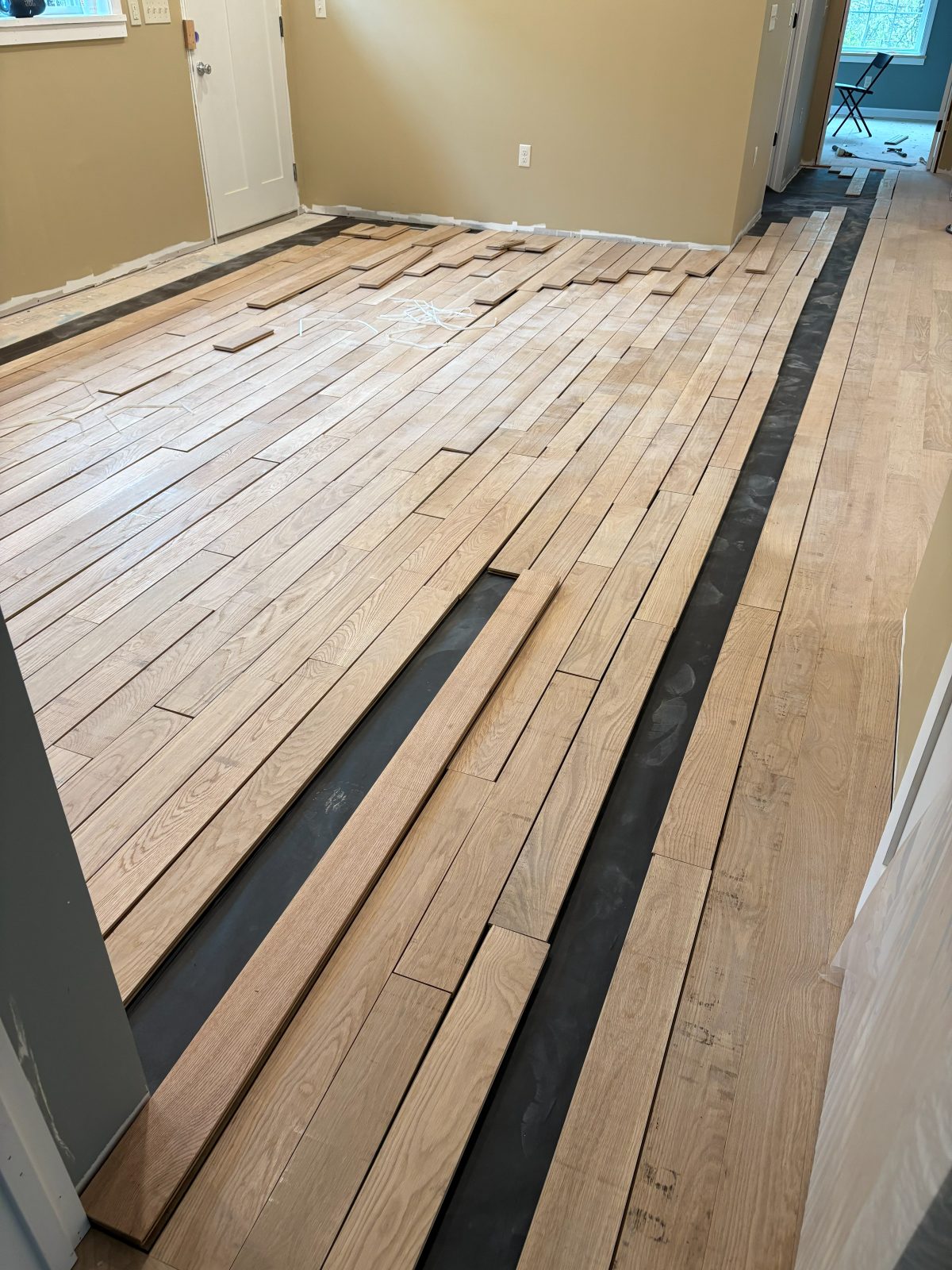 New hardwood boards being laid across a room